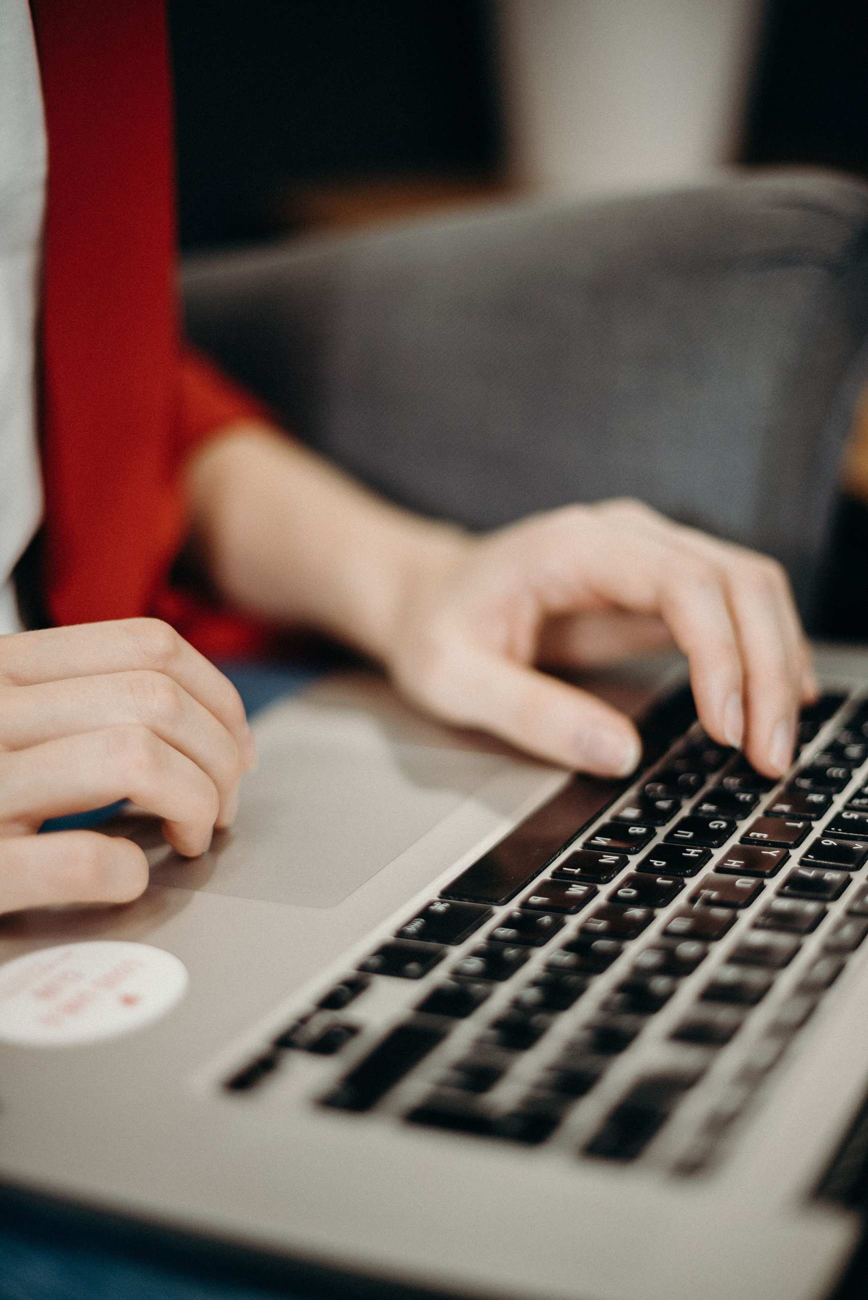 Hands typing on a laptop in an office setting