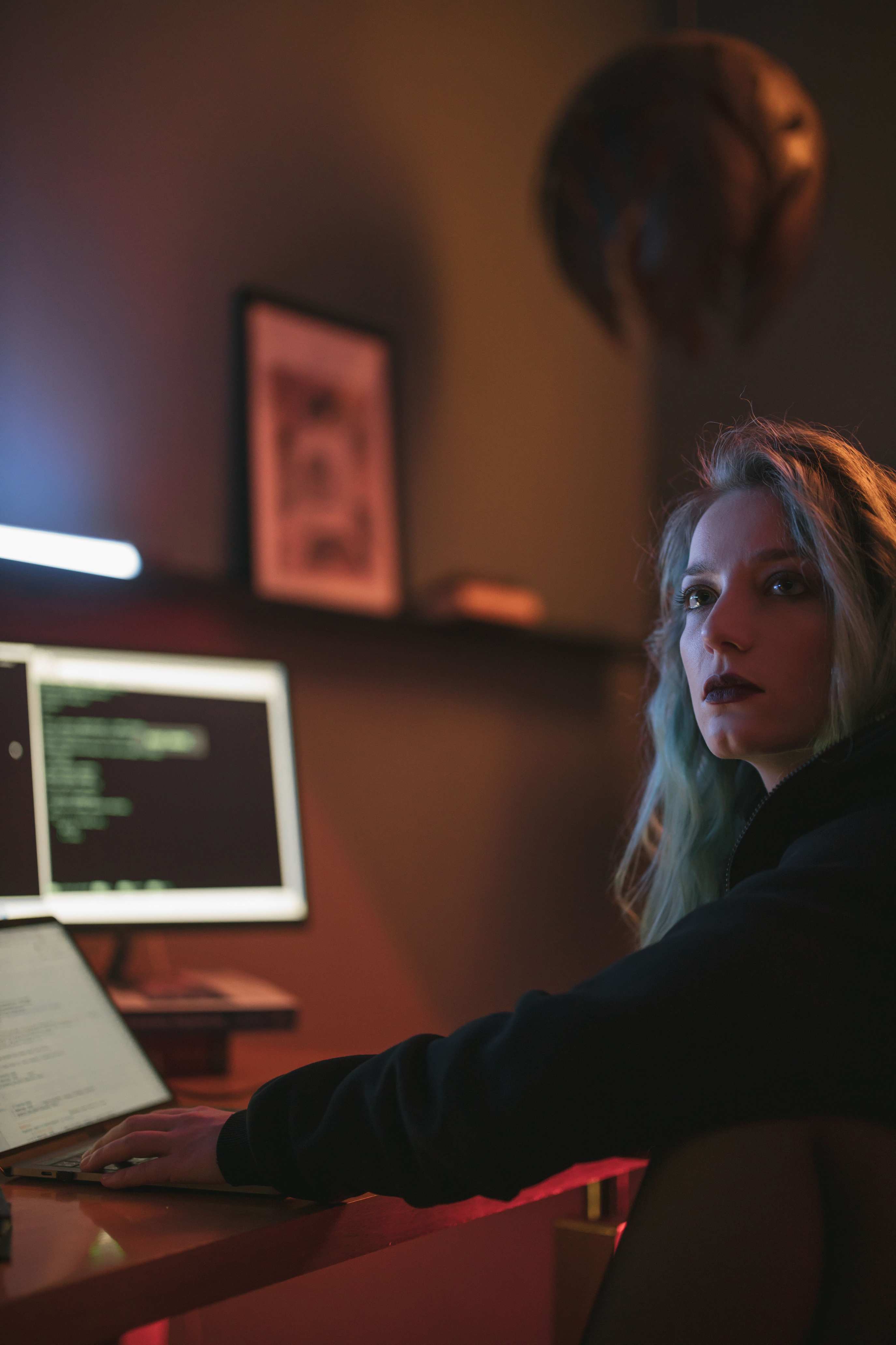 Laptop showing code on a desk in a dimly lit room